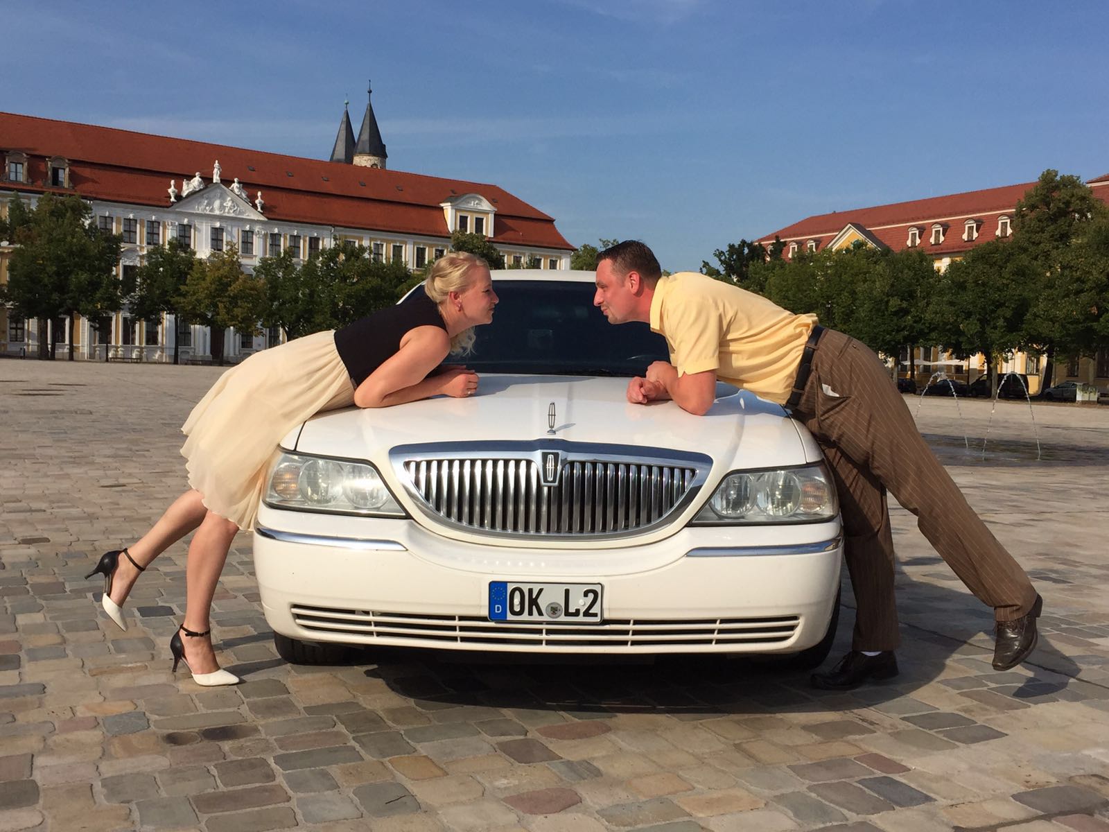 Päärchen posiert vor weisser Miet-Limousine für Stadtrundfahrt in Magdeburg