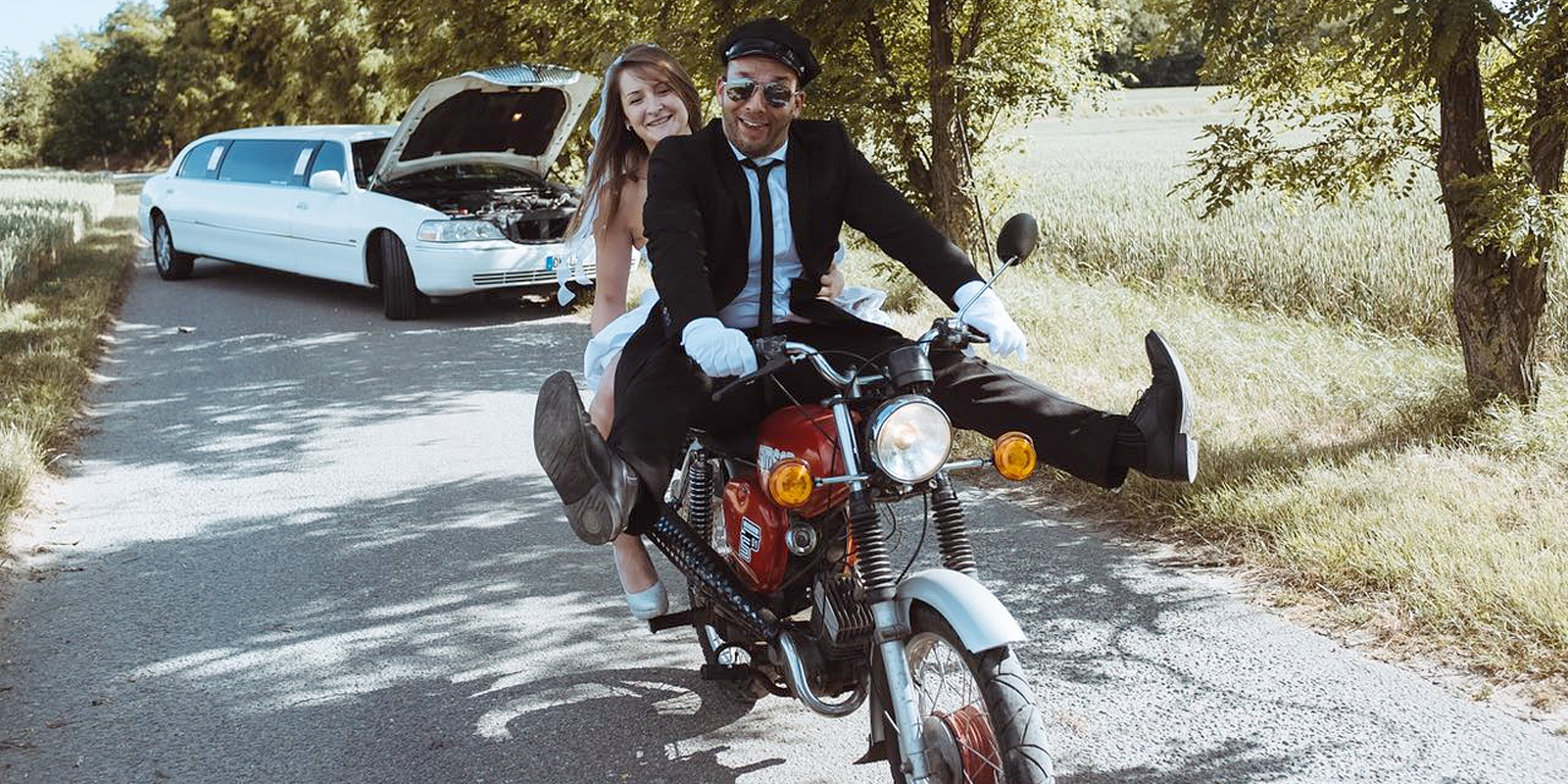 Braut fährt mit Chauffeur auf Motorrad von weisser Limousine weg