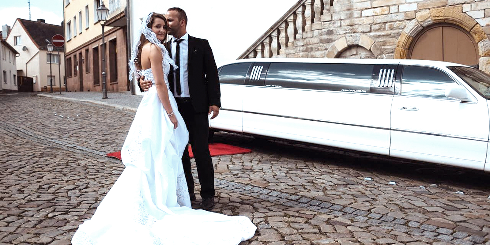 Brautpaar vor weisser Hochzeitslimousine vom Limousinenservice OK-Limo stehend